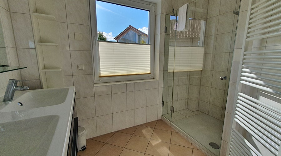 Paar entspannt im Bett und isst Erdbeeren unter einem Wandbild mit Fischerboot